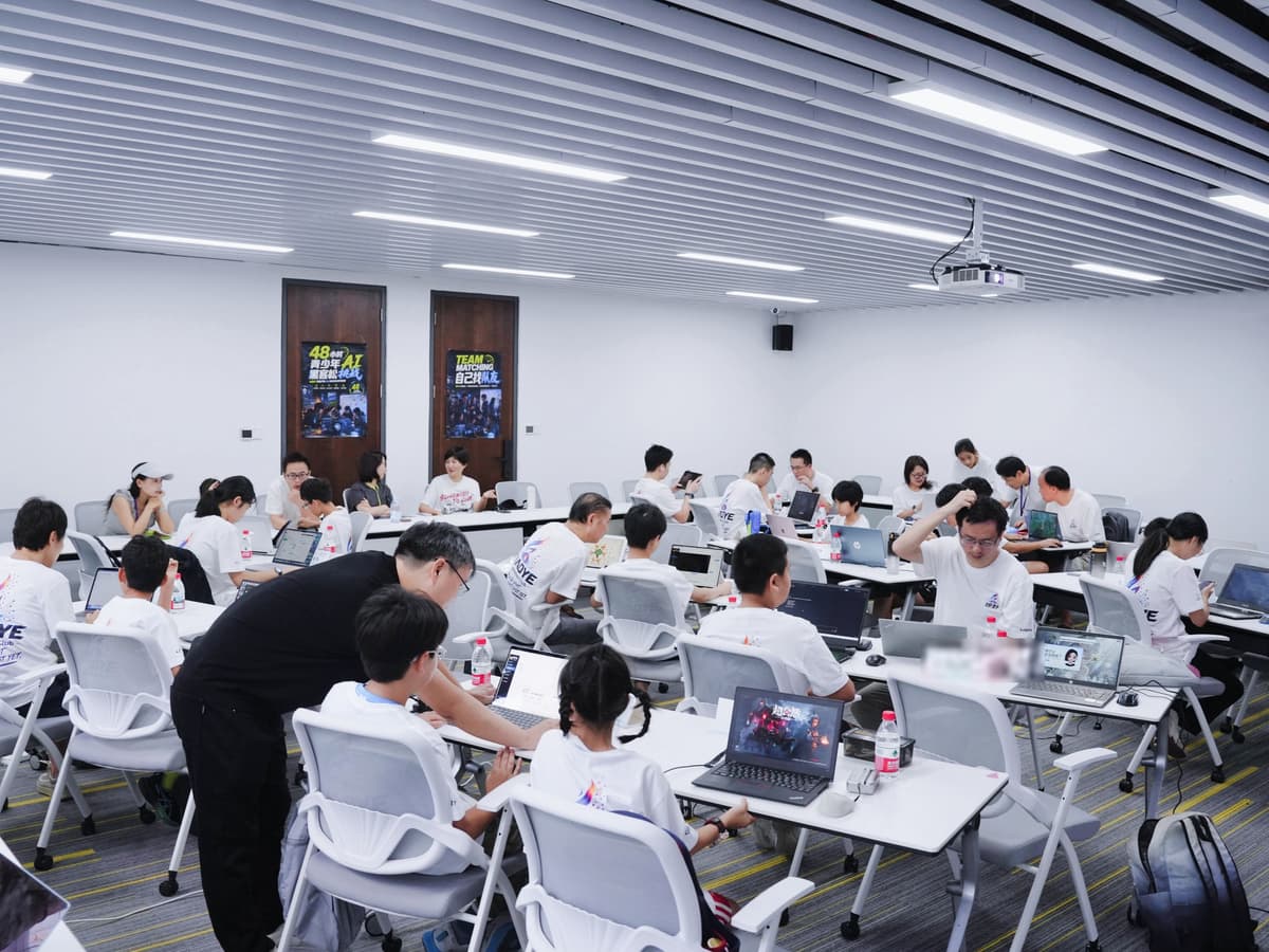 深圳亲子 AI 黑客松开发现场:孩子和家长分散在各张桌子上做各自的项目,导师在桌边俯身指导