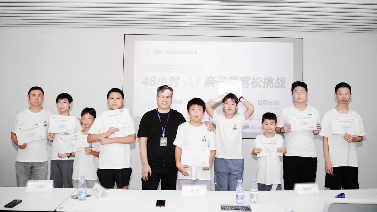 燎野深圳首场 48 小时亲子 AI 黑客松结营合影,Builder 们拿着结营证书站在活动投影前